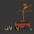 Tree with Yellow and Red Leaves in Red Cart Surrounded by Green Grass