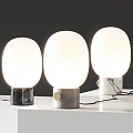 Modern Table Lamps With White Spherical Shades And Marble And Gray Bases On White Surface