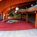 Hotel Lobby With Curved Wooden Structure Red Carpet And Hanging White Spherical Lights
