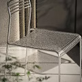 Modern Minimalist Metal Leisure Chair With Silver Frame And Mesh Design In Natural Light