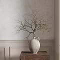 White Textured Ceramic Vase With Leafless Branches On Wooden Table By Light Colored Wainscoted Wall