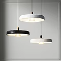 Modern Black And White Circular Pendant Lights With Metallic Accents In Illuminated Indoor Space