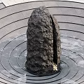 Rustic Stone And Wood Garden Feature With Concentric Circular Ground Patterns