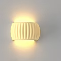 Cream Colored Ribbed Wall Lamp With Soft Glow Mounted On White Wall