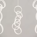 Three Modern Pendant Lights Featuring Multiple Circular Rings Against Gray Wall Background 3d model