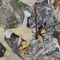 Broken Old Weathered Wooden Planks And Metal Sheets In Ash Debris With Overgrown Grass