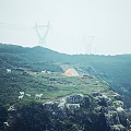 Foggy Hillside With White Sheep Orange Tent Power Towers Rocks And Green Vegetation