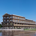 Traditional Wooden Multi story Commercial Street Featuring Balconies Pedestrian Walkway And Wet Pavement Under Blue Sky