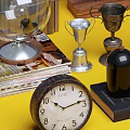 Vintage Decorative Ornament Combination With Globe Trophy Clocks Bottles Books And Pine Cones On Yellow Background