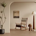 Cozy Rocking Leisure Chair with Side Table Floor Lamp Woven Wall Art and Potted Plant