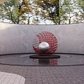 Red Spherical Sculpture With Silver Center In Circular Pool Surrounded By Trees And Gray Wall