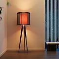 Modern Wooden Tripod Floor Lamp With Fabric Shade In Warm Lit Room Interior