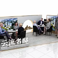 Modern Exhibition Booth Tables and Chairs with People Interacting and Display Backdrops