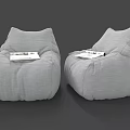 Two Gray Linen Bean Bag Chairs with Magazines for Comfortable Seating