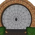 Black Wrought Iron Spider Web Design Gate With Red Brick Arch And Green Shrubs