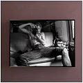 Shirtless Male Portrait Painting on Sofa Holding Camera in Car Interior Black White Style