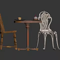 Round Wooden Table With Two Chairs One Wooden And One Ornate Metal With Plates