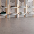 Multiple Modern Washbasins with Circular Mirrors Recessed Lighting White Walls and Gray Flooring