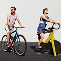 Two men riding different bikes one on road bicycle and one on exercise bike