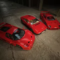 Three Red Vintage Sports Cars Parked In Spacious Garage Interior With Classic Design