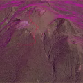 Aerial View of Green Mountainous Volcanic Terrain With Red Trail and Crater