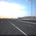 Highway Bridge with Vehicles Driving Under Street Lamps at Sunset with Grass and City Background