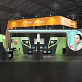 Company Exhibition Booth Design With Green Orange Accents And Product Displays