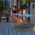 Evening Lit Commercial Street with Outdoor Dining White Umbrellas Trees and Pedestrians