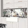 White Kitchen Sink With Brass Faucet Marble Patterned Backsplash And White Cabinets On Kitchen Countertop