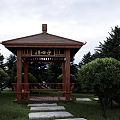 Traditional Wooden Pavilion with Stone Path and Green Lawn Among Trees