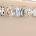 Cute Soft Kids Clothes Display With Light Colors And Cartoon Prints On Hangers