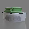 Transparent Plastic Storage Bin with Folded Blankets and Green Towels Inside