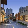 Lively Commercial Street Evening Ambiance With Modern Buildings Outdoor Seating Decorative Lighting and Green Plants