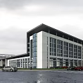Modern Multi Story Office Building With Glass Curtain Walls And Parking Area