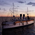 Vintage White Yacht With Gold Accents Sailing On Ocean Under Cloudy Sky