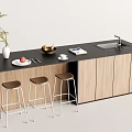 Kitchen Bar with Black Countertop Wooden Cabinets Three Bar Stools Plant Fruit Bowl and Sink