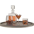 Wine Bottle and Glasses on Round Silver Tray with Ice Cubes and Amber Liquid