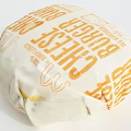 Fresh Tasty Cheeseburger Wrapped in Paper Packaging with Cheese Label