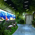 Lush Green Plant Decor With Tree Branch Archway And Large Aquarium Featuring Colorful Fish