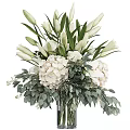 Decorative Ornament Arrangement With White Lilies Hydrangeas And Green Leaves In Glass Vase