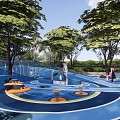 Fun Children's Play Area With Curved Blue Track And Kids Playing Surrounded By Trees