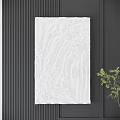 White Textured Sculptural Wall Decor on Dark Background With Green Plant Accent