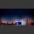 Modern Commercial Equipment Display Setup With Circular Booth Curved Structure And City Backdrop Lighting Effects