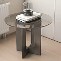 Modern Round Glass Top Side Table With Metal Frame And Decorative Books On Wooden Floor
