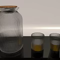 Glass Ribbed Pitcher With Wooden Lid And Yellow Liquid Cups On Black Table