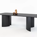 Modern Black Wooden Dining Table With Cylindrical Legs Topped With Brown Bottle And Small Cup