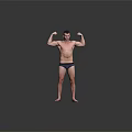 A Man Flexing Muscles Shirtless In Dark Underwear Standing Against Gray Background