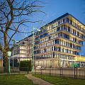 Modern Multi Storey Office Building With Glass Facade Trees Lawn And Street Lamp
