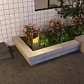 Outdoor Lights By Rectangular Flower Bed With Pink Flowers Green Plants And White Tiled Wall