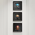 Three Character Portraits In Black Frames Hanging On White Wall 3d model